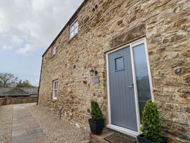 An exterior view of a stone wall with a door and planters at The Granary in Durham