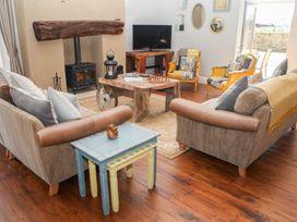A living room with sofas, coffee table, TV and armchairs at The Granary in Durham