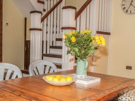 A dining room with a table and vase of flowers at The Granary in Durham