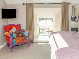 A bedroom with an armchair and television at The Granary in Durham