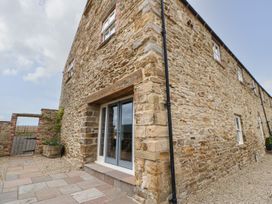 An outdoor area with stone walls and a paved pathway at The Granary in Durham