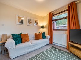 A living room with a sofa, lamp, pictures and television at Cabin 1 Moffat Manor Beaufort