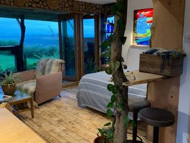 A living room with a chair and a bed at The Retreat Cabin in Llanelli