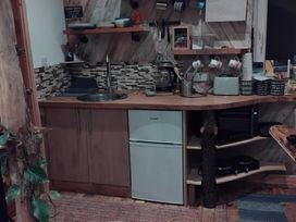 A kitchen with a sink, refrigerator, and coffee maker at The Retreat Cabin in Llanelli