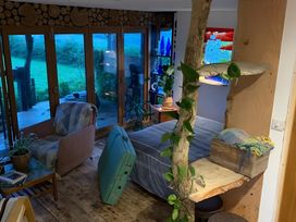 A living room with a bed and sofa at The Retreat Cabin in Llanelli