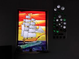 A stained glass window depicting a ship on the ocean at The Retreat Cabin in Llanelli