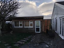 An outdoor area with a cabin and patio at The Retreat Cabin in Llanelli