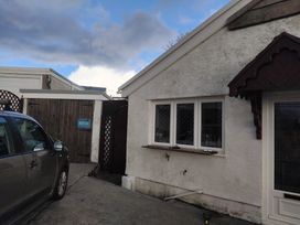 An outdoor view of a building with windows and a car at The Retreat Cabin in Llanelli