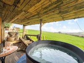 An outdoor space with a hot tub and table at The Retreat Cabin in Llanelli