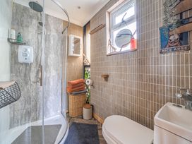 A bathroom with a shower and toilet at The Retreat Cabin in Llanelli