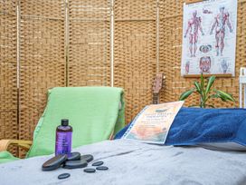 A treatment room with massage oil and stones at The Retreat Cabin in Llanelli