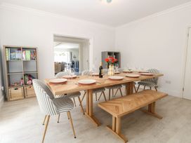 A dining room with a wooden table and striped chairs at Cootiya Corner in Great Lyth
