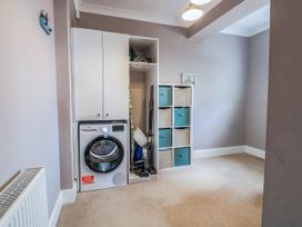 A utility room with a washing machine and storage cabinets at Cootiya Corner in Great Lyth