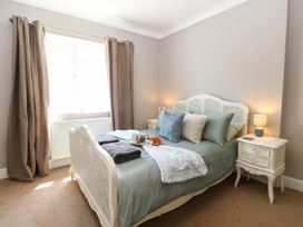 A bedroom with a bed, nightstand, and window at Cootiya Corner in Great Lyth