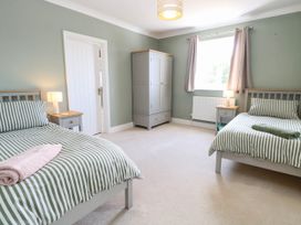 A bedroom with two beds and a wardrobe at Cootiya Corner in Great Lyth