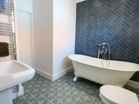 A bathroom with a bathtub, toilet, towel rail, and hand basin at Cootiya Corner, Great Lyth