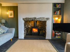 A living room with a fireplace and bookshelves at Seren Fach in Pwllheli