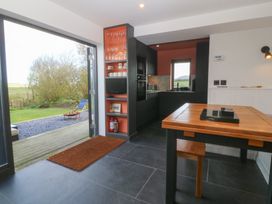 A kitchen with a table and chairs at Seren Fach in Pwllheli