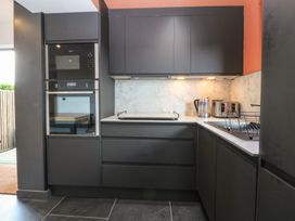 A kitchen with built-in appliances and cabinets at Seren Fach in Pwllheli