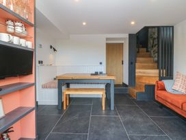 A dining room with a table and sofa at Seren Fach Pwllheli