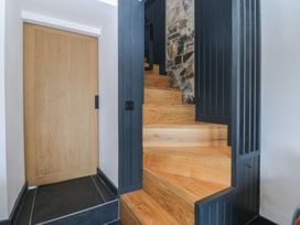 A staircase with wooden steps and a wooden door at Seren Fach Pwllheli