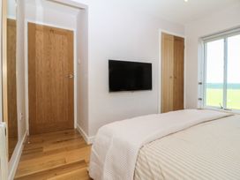 A bedroom with a bed and television at Seren Fach in Pwllheli