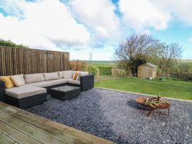 A garden with a sectional sofa and fire pit at Seren Fach in Pwllheli