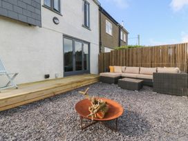 A garden with outdoor seating and a fire pit at Seren Fach Pwllheli