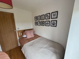 A bedroom with a bed and wall art at Seren Fach near Aberdaron