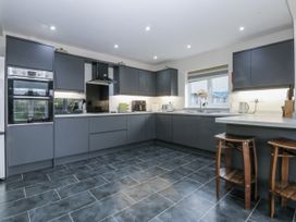 A kitchen with modern appliances and cabinets at Benlli in Pwllheli