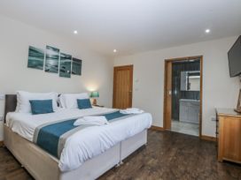 A bedroom with a bed and access to a bathroom at Benlli in Pwllheli