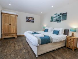 A bedroom with a bed and wardrobe at Benlli in Pwllheli