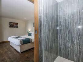 A bedroom with a bed and a shower at Benlli in Pwllheli