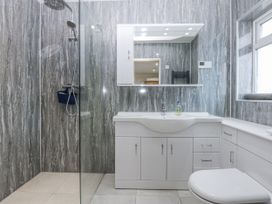 A bathroom with a shower and vanity unit at Benlli in Pwllheli