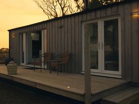 An outdoor area with chairs and a decorative pouf at The lodge at Plumstone View in Haverfordwest