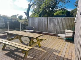 An outdoor seating area with a wooden table and chairs at The lodge at Plumstone View Haverfordwest