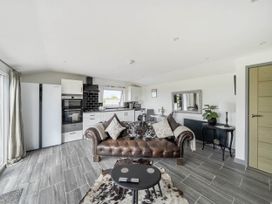 A living room with a couch and kitchen appliances at The lodge at Plumstone View in Letterston