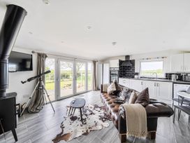 A living room with a television, sofa, and telescope at The lodge at Plumstone View in Letterston