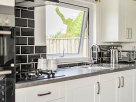 A kitchen with a window and appliances at The lodge at Plumstone View Letterston
