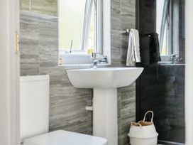 A bathroom with a toilet, sink, and shower at The lodge at Plumstone View in Letterston