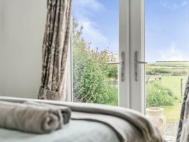 A view from a bedroom window with curtains and towels at The lodge at Plumstone View in Letterston
