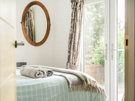 A bedroom with a bed and a mirror at The lodge at Plumstone View Letterston