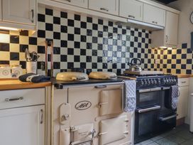 A kitchen with stove, kettle and cooking utensils at Ellishayes Farm in Combe Raleigh
