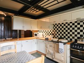 A kitchen with cabinets, stove, sink and microwave at Ellishayes Farm in Combe Raleigh