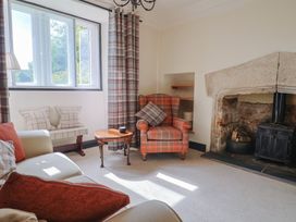 A living room with a fireplace and armchair at Ellishayes Farm in Combe Raleigh