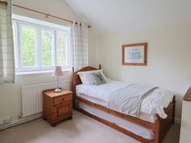 A bedroom with a single bed and a nightstand at Ellishayes Farm in Combe Raleigh