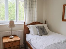 A bedroom with a single bed and a nightstand at Ellishayes Farm in Combe Raleigh