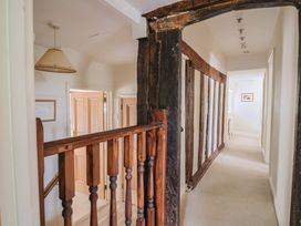 A hallway with a staircase and doors at Ellishayes Farm in Combe Raleigh