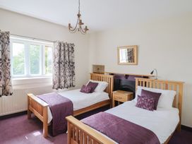 A bedroom with two beds and a window at Ellishayes Farm in Combe Raleigh