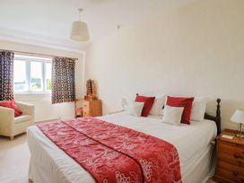 A bedroom with a bed and chair at Ellishayes Farm in Combe Raleigh